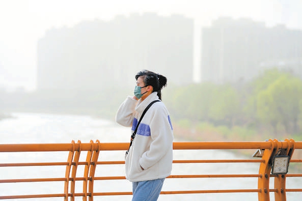 3月22日，沙尘天气来袭，市民经过亦庄新城滨河公园。
