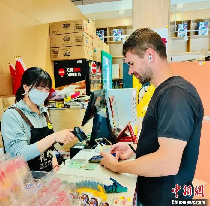 圖為外籍游客在北京八達嶺長城景區商店內體驗電子支付。