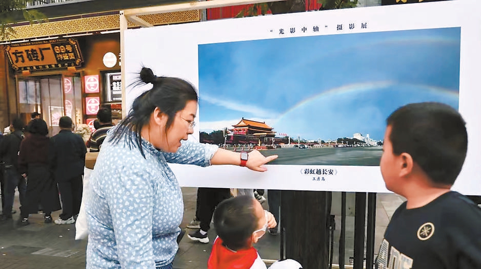 前門大街的遊客通過展覽上的攝影作品領略中軸線風光。東城區文聯供圖