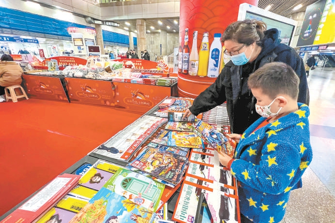 旅客在北京西站“福滿京城 春賀神州”春節主題書香市集翻閱選購圖書雜誌。