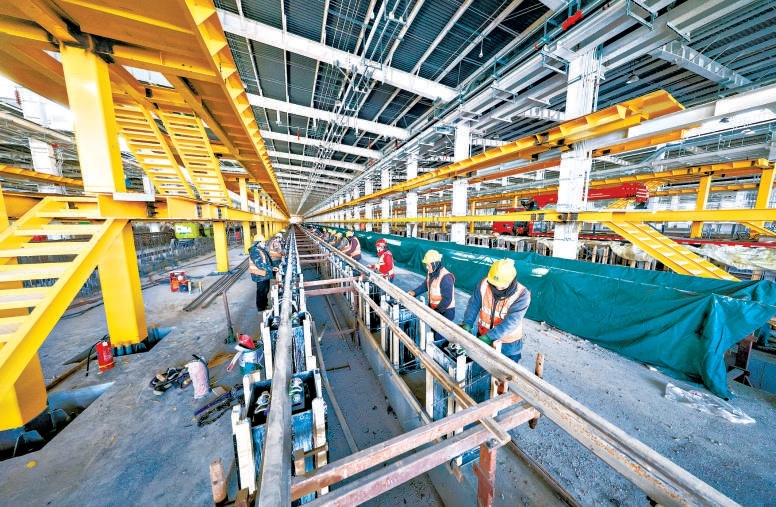 在軌道交通22號線平房停車場施工現場,工人們在運用庫裏舖設軌道,現場忙得熱火朝天。 在軌道交通22號線平房停車場施工現場,工人們在運用庫裏舖設軌道,現場忙得熱火朝天。