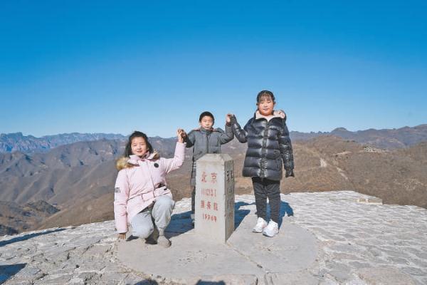 1月24日，劉雨諾（左）、張金平（中）和孔德穎（右）三名小朋友在京津冀三界碑前手拉手約定，將來一起去看更大的世界。
