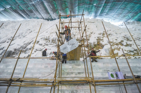 工人用轮滑将大块的冰运到高空进行加工创作。