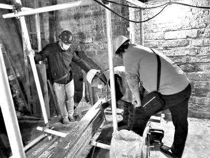老工匠指導施工人員在同興和木器店舊址現場修繕。