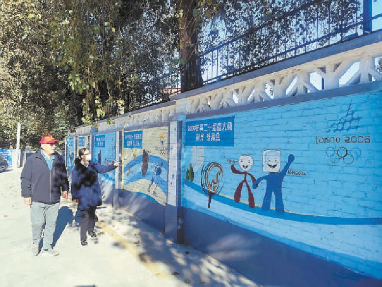 2021年10月19日，石景山区冬奥社区的冬奥文化墙正式亮相。近百米长的文化墙绘制了自1924年至2018年共举办了的23届冬奥会和即将举办的北京冬奥会，成为冬奥文化展示墙。（吴镝 摄）