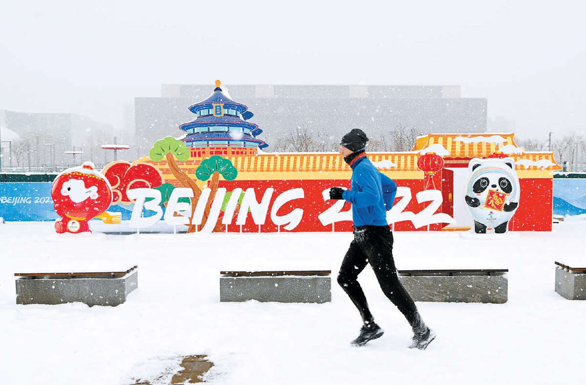 2022年2月13日，一名男子在北京2022年冬奥会和冬残奥会主媒体中心外的区域冒雪跑步。（武巍 摄）