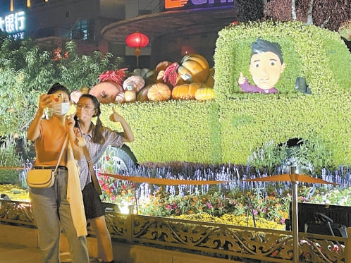 9月28日晚，华灯初上，在西单路口的各个花坛前，很多市民前来打卡。