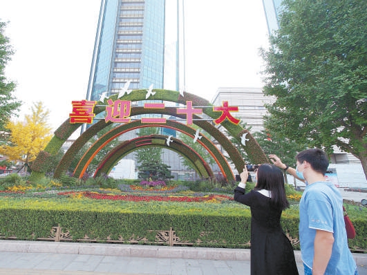 在北京双子座大厦前，市民拍摄“喜迎盛会”花坛。