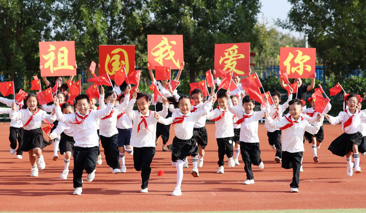 2024年9月29日，山東省臨沂市郯城縣第一實驗小學學生手持國旗快樂奔跑，喜迎國慶節。