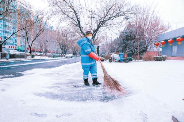 1月23日，北京环卫集团平谷公司道路清扫保洁员在建设西街扫雪铲冰。