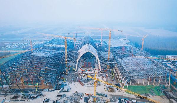 11月17日，随着最后一榀钢拱的拱顶顺利吊装到位，廊坊临空国际会展中心项目会议中心部分钢结构主体顺利封顶。