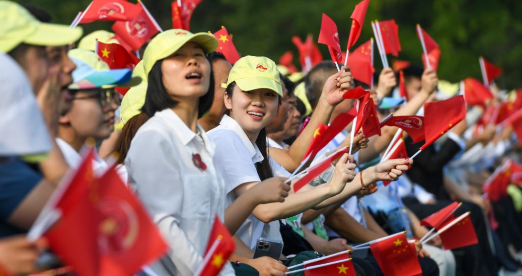 9月3日，紀念中國人民抗日戰爭暨世界反法西斯戰爭勝利80周年大會在北京隆重舉行。這是觀眾在揮舞國旗。
