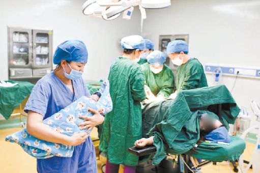 11月26日，通州区妇幼医生苏涛（右一）和助产士刘洋（左一）在廊坊市妇产医院为产妇手术接生。