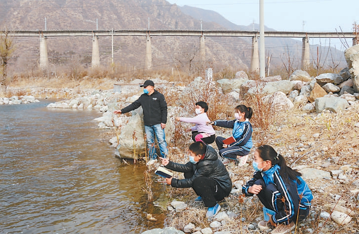 图为门头沟“城乡教育发展联盟”的带队老师带着孩子们在永定河边观鱼赏鸟。