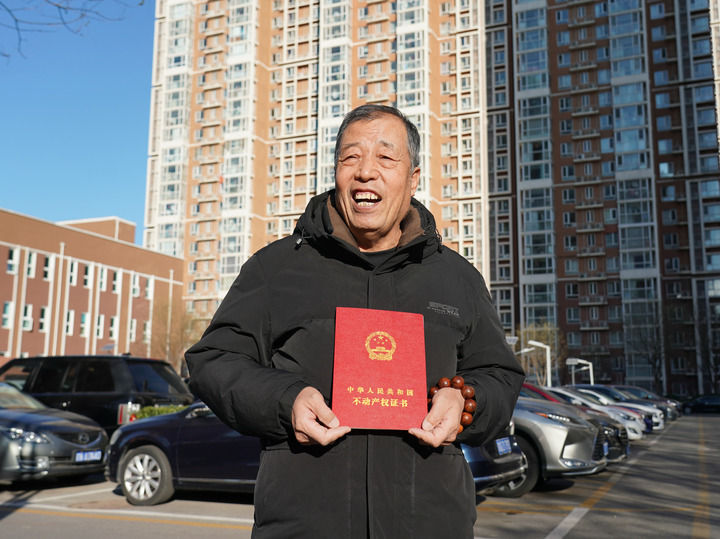 12月16日，一名西城区京铁和园小区的居民向记者展示新办理的不动产权证书。