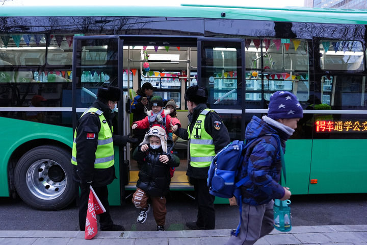 12月16日，北京公交集团通学368路车停靠在呼家楼中心小学通学车终点站，小学生在通学乘务员徐洁（后）和工作人员引导下下车。