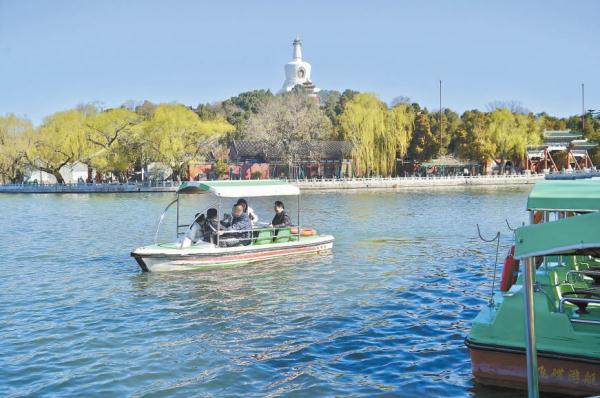 在北海公园，游客泛舟太液池上。