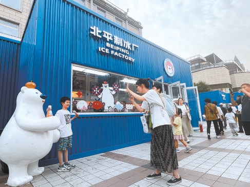 在北平制冰厂门店前，小游客正和憨态可掬的“冰冰熊”合影留念。