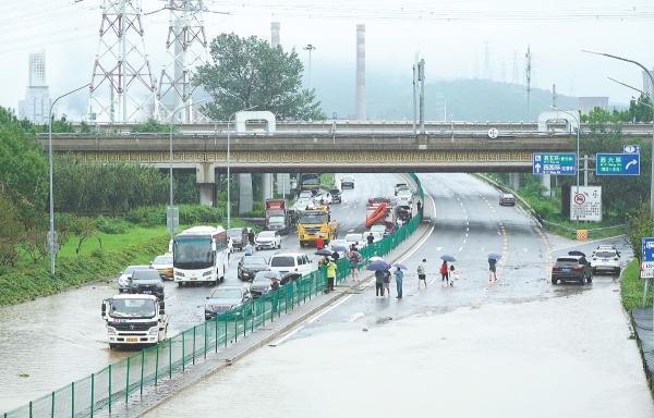 7月31日，门头沟区双峪桥下积水，人们纷纷下车步行。救援人员赶赴现场，交警打开路中间隔离带，部分车辆掉头行驶。