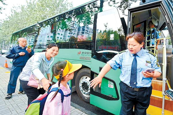 9月4日，在海淀区上地佳园小区门外，小学生和家长搭乘通学定制公交15路前往学校。