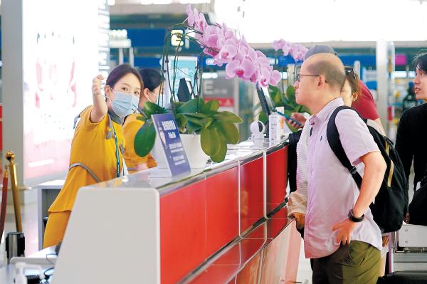 9月26日，在首都国际机场，工作人员为出行旅客提供指引服务。