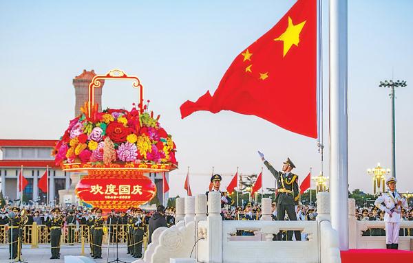 升旗手高高扬起国旗，鲜艳的五星红旗迎风招展，在庄严的国歌声中缓缓升起。