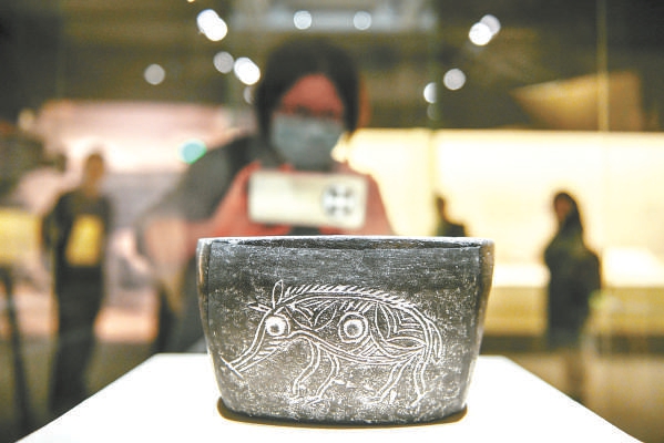 浙江省博物馆馆藏河姆渡文化猪纹陶钵在展览上展出。
