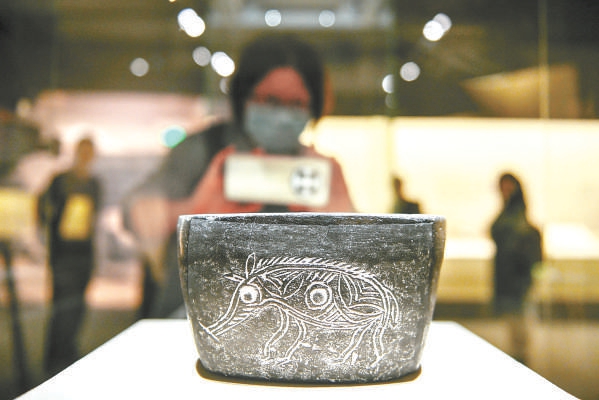 浙江省博物馆馆藏河姆渡文化猪纹陶钵在展览上展出。