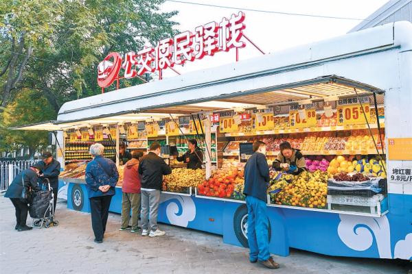 在马官营公交便民驿栈，市民在选购蔬菜水果等商品。