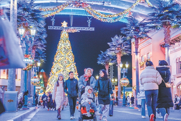 11月30日晚，游客在流光溢彩的北京环球度假区好莱坞景区游览。