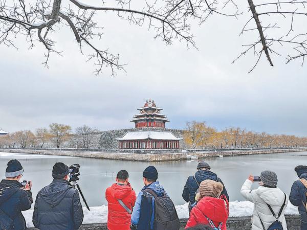12月11日上午，在故宫西北，雪中角楼吸引不少市民游客赏景拍照。