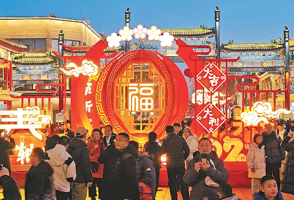 春节假期，前门步行街节日景观照明逐渐点亮，给北京的节日氛围增添了独特魅力。夜色中的前门商圈流光溢彩、游人如织。“中轴线上过大年”主题景观前，游客纷纷拍照打卡。