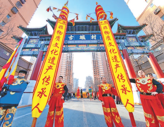 2月11日是农历大年初二，“秉心圣会”十档花会玩角儿，身着红袍、绿衣、黄褂、白衫依次出场。时隔四年，在古城村牌楼下重现民俗踩街表演，吸引众多市民观看。据悉，位于石景山区古城街道古城村的“秉心圣会”始于明代万历年间，传承至今已有400多年。