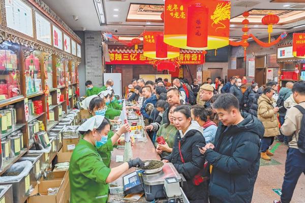 春节假期，前门大街周边老字号生意兴隆，在张一元总店，市民游客排队选购茶叶。