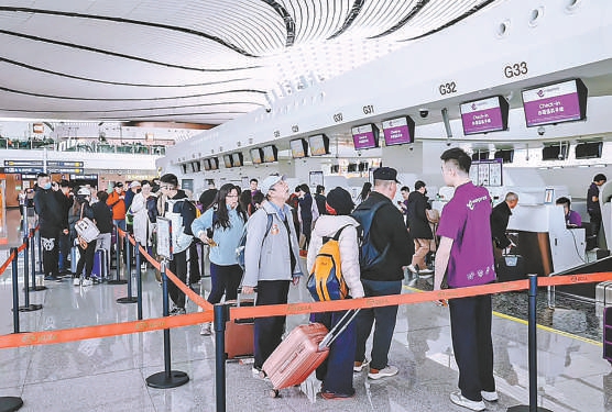 搭乘香港快运航空的乘客在大兴机场柜台办理登机手续。
