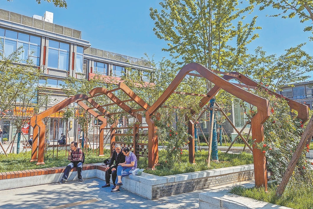北新桥路口东北角原围挡已拆除，新建成的小花园为市民提供绿色休闲空间。