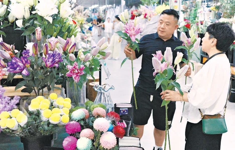 逛花街夜市的市民顺便走进北京花卉交易中心挑选鲜花。