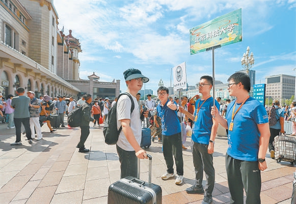 8月28日，高校志愿者在北京站出站口迎接新生。