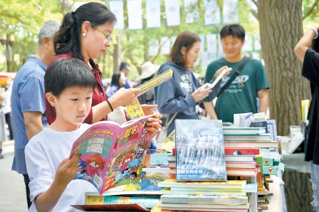 中秋假期第二天，地坛书市吸引更多的少年读者来此阅读、休闲。