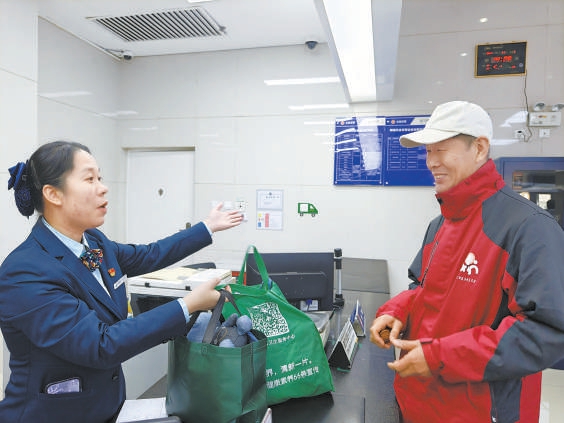 东四邮局营业员为李久居老人办理旧物回收业务。