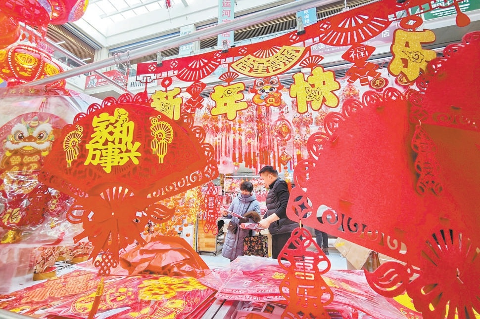 新年临近，京城节日气氛渐浓。在通州区一家市场，烘托节日气氛的年货把市场装点得红红火火，顾客前来选购年货，迎接新年的到来。
