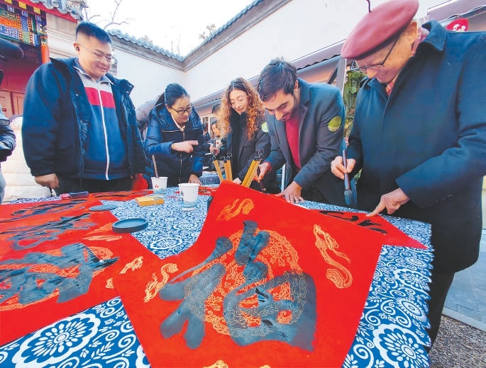 1月21日的八大处新春庙会预热探秘活动上，外国留学生在书法老师的带领下学习中国书法。