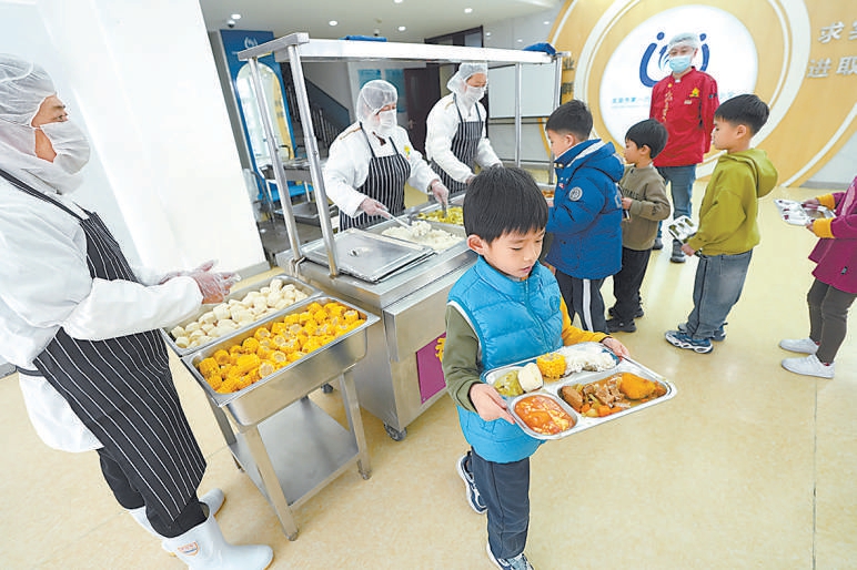 2月20日，校尉胡同小学学生使用统一清洗消毒的餐具盛饭菜。