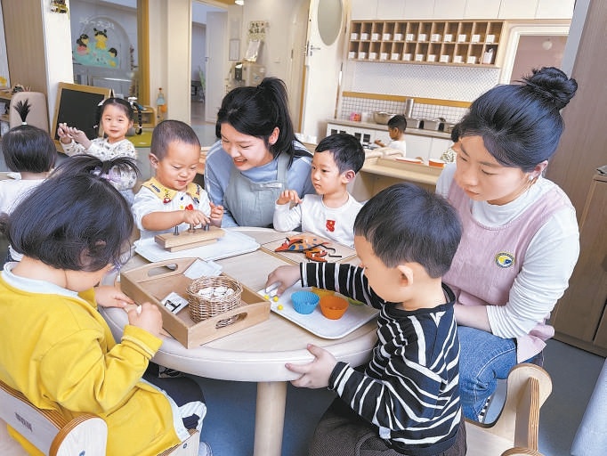 王明伟（中间蓝衣服）在北科婴幼学苑实习。