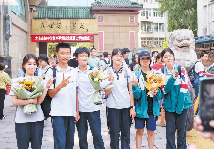 6月25日，北京景山学校考点外，考生手持鲜花合影留念，记录下这一重要时刻。