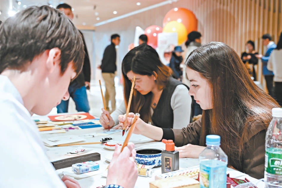 中外嘉宾参与剪纸、书法、点梅、非遗饰品制作等互动体验。