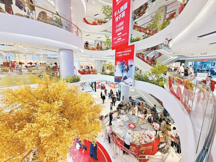 昨天，新华百货CC mall重新开业，顾客排队品尝饺子。