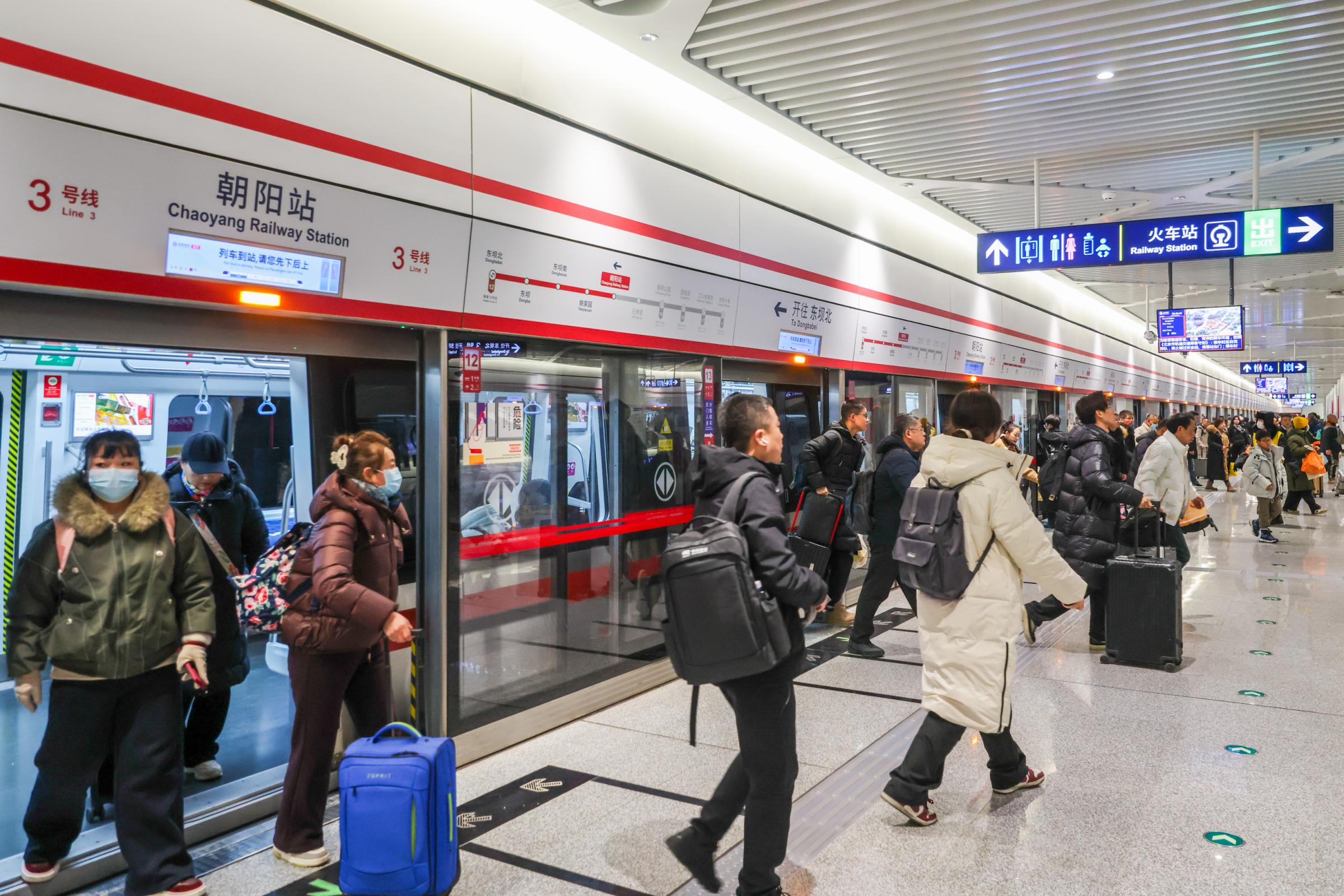 旅客带着行李搭乘地铁3号线到达朝阳站。