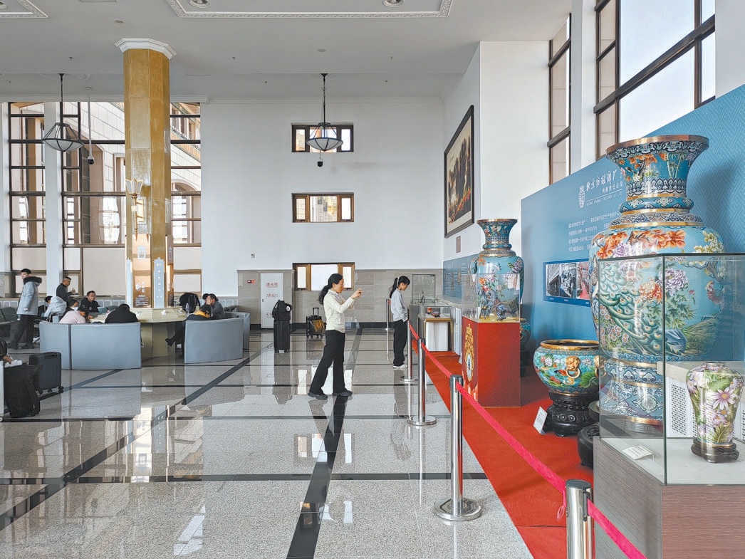 北京站候车厅旅客利用候车时间参观展览。