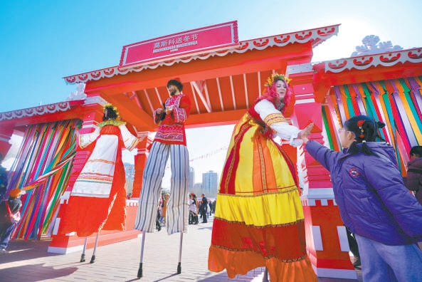 踩着高跷的艺人与观众亲密互动。